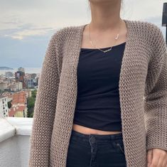 a woman standing on top of a roof with her hands in her pockets