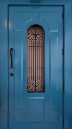 a blue front door with an iron grill on the top and side panels, along with a black handle