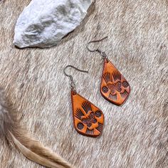 "Hand tooled earrings made from veg tanned leather and hand dyed in a soft tan color. Lightweight and flexible for all day wear.  Dimensions: 1.5\" earwire adds about .5\" to total length.  Materials: Veg tanned leather  Care: No not keep wet for long periods of time, remove before swimming or showering. Store hanging or laying flat.  Nickel and lead free ear post for sensitive ears  Each item is uniquely handcrafted and might have slight variations  Follow us on Instagram! https://www.instagram Bohemian Hand-tooled Leather Earrings, Artisan Leather Nickel-free Earrings, Handmade Brown Earrings For Everyday Use, Leather Teardrop Earrings For Everyday Use, Everyday Brown Teardrop Jewelry, Artisan Leather Teardrop Earrings, Hand Tooled Brown Dangle Earrings, Brown Hand Tooled Dangle Earrings, Handmade Southwestern Leather Earrings