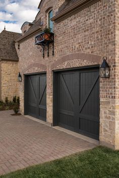 a large brick building with two garage doors on each side and an attached light fixture