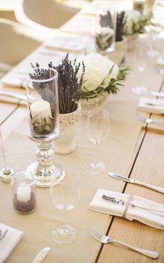 the table is set with white flowers and place settings for guests to sit down at