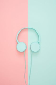 a pair of headphones sitting next to each other on a pink and blue background