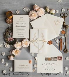 the wedding stationery is laid out on top of each other with flowers and stamps