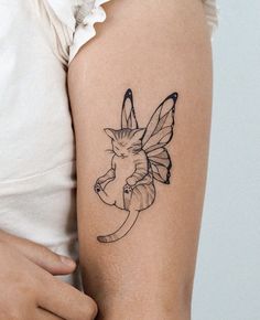 a woman's arm with a small tattoo of a cat and a butterfly on it