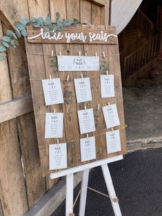 a wooden sign with seating cards attached to it