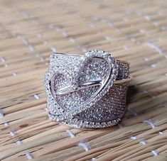 a diamond ring sitting on top of a wooden table next to a straw mat with white dots