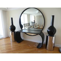 a mirror sitting on top of a table next to vases