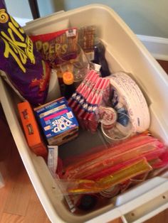 a container filled with lots of food on top of a hard wood floored floor