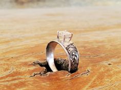 two wedding rings sitting on top of a wooden table next to each other, one with a diamond in the middle