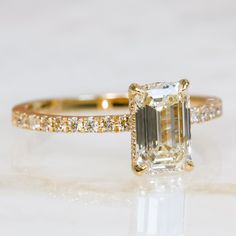 an engagement ring with a large green diamond in the center and side stones around it