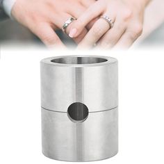 a couple holding hands over a metal trash can with their wedding rings on the top