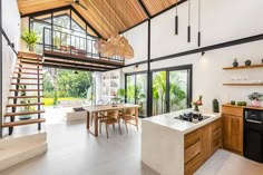 an open concept kitchen and dining area with stairs leading up to the second floor that has glass doors on both sides