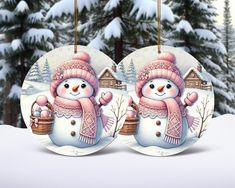 two snowmen with hats and scarfs are hanging from a christmas ornament