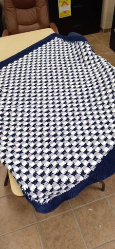 a blue and white blanket sitting on top of a table