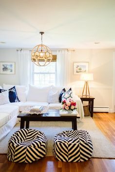 a living room filled with furniture and a chandelier hanging over the top of it