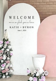 a welcome sign next to flowers and a vase