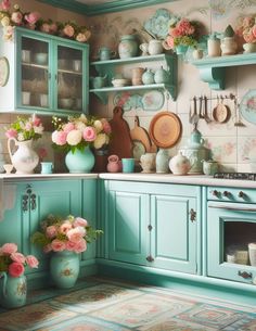 a kitchen with blue cabinets and pink flowers in vases