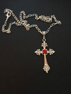 Large silver tone cross on chunky chain with a red faux gem 24in long cross s 2.5in x 1.5in silver plated chain and a lobster claw fastening clasp Metal Cross Necklace With Chain, Metal Cross Necklace With Chain Pendant, Metal Cross Pendant Necklace With Chain, Gothic Cross Chain Jewelry, Silver Metal Cross Necklace, Gothic Sterling Silver Cross Necklace, Red Gothic Cross Necklace, Gothic Silver Metal Cross Necklace, Gothic Cross Necklace With Adjustable Chain