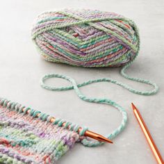 a ball of yarn next to a crochet hook