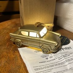 a toy car sitting on top of a wooden table next to a piece of paper