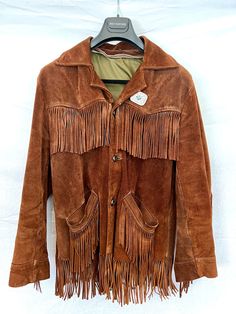 Purchased vintage, worn with love, excellent condition.  Missing the lining, but has a full zipper to add in one!  Thick, high quality brushed chocolate brown suede, with an added bonus pin I put on it.  Beautiful brown leather braided buttons, signs of wear/tear, but tons of life left.  Reminiscent of Old Western/Cowboy, but also of current fashion brands Saint Laurent, Celine, and more. Vintage Fitted Outerwear With Fringe, Fitted Vintage Outerwear With Fringe, Vintage Brown Fringed Outerwear, Vintage Brown Fringe Outerwear, Old Western Cowboy, Fringe Coat, Fringe Coats, Old Western, Vintage Chocolate