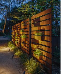 a wooden fence with plants growing on it at night in the park or garden area