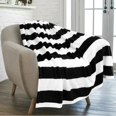 black and white striped blanket sitting on top of a chair in front of a window