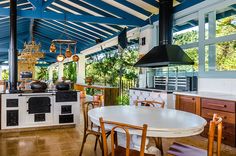 a kitchen with an oven, stove and dining room table in it's center