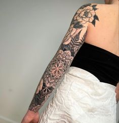 a woman with a flower tattoo on her left arm and right arm is wearing a white skirt