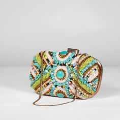 Colorful beaded clutch, highlighted by a striking turquoise bead. The clutch is secured with a clasp closure and offers versatility with a detachable gold shoulder strap for added convenience. Turquoise Rectangular Shoulder Bag For Evening, Turquoise Rectangular Evening Shoulder Bag, Multicolor Bohemian Bags For Formal Occasions, Multicolor Summer Clutch Evening Bag, Multicolor Clutch Evening Bag For Summer, Embellished Clutch For Summer Evenings, Bohemian Beaded Clutch, Summer Embellished Rectangular Clutch, Chic Beaded Clutch For Events