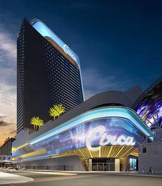 an illuminated building in the evening with palm trees