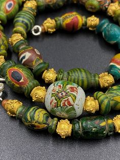 A beautiful collection of very old Ancient glass beads all in vibrant colors natural From Ancient Roman's times with beautiful hand made ancient antique 18 karat gold beads Total weight gold : 12.1.gm Antique Large Gold Beads, Handmade Green Byzantine Jewelry, Antique Jewelry With Colorful Oval Beads, Ceremonial Festival Jewelry With Colorful Beads, Traditional Green Necklace With Oval Beads, Traditional Green Necklaces With Oval Beads, Artisan Hand-strung Gold Beads, Antique Spacer Beads Jewelry, Hand-strung Artisan Gold Beads