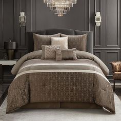 a bedroom with a chandelier hanging from the ceiling and pillows on the bed