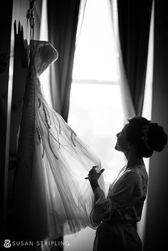 a woman is standing in front of a dress