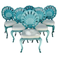 four chairs and two stools with fan shaped backrests in turquoise, set against a white background