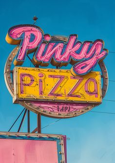 the neon pink and yellow sign for pikey's pizzeria is shown against a blue sky