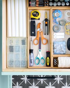 an organized drawer with scissors, tape and other crafting supplies on top of it