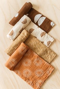 five different colored napkins on top of a wooden table