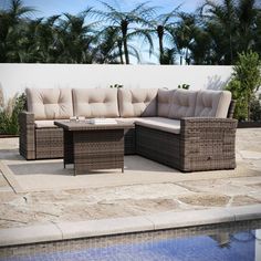 a wicker couch sitting on top of a patio next to a swimming pool