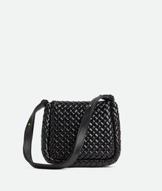 Find BOTTEGA VENETA Mini Cobble Shoulder Bag on Editorialist. This Bottega Veneta mini shoulder bag is crafted from padded Intreccio leather. It features a flap closure with a metal clasp, one interior zippered pocket, one open pocket, and a gold finish hardware. The bag measures 17 cm in height, 19 cm in width, and 6 cm in depth. The shoulder strap has a drop of 21 cm. It is unlined and made from lambskin. Leather Bucket Bag With Intrecciato Weave Crossbody, Versatile Leather Shoulder Bag With Intrecciato Weave, Woven Leather Pouch Shoulder Bag, Leather Satchel With Intrecciato Weave For Evening, Leather Intrecciato Weave Crossbody Shoulder Bag, Formal Woven Leather Crossbody Bag, Leather Intrecciato Clutch Shoulder Bag, Evening Woven Leather Crossbody Bucket Bag, Versatile Black Shoulder Bag With Intrecciato Weave