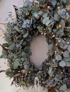 a wreath with green leaves and yellow berries