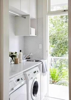 a washer and dryer in a small room with open doors to the outside