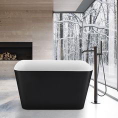 a bath tub sitting next to a fireplace in a room with wood walls and windows