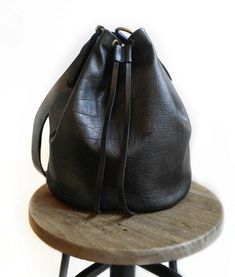 Bucket bag made with cblack soft leather. This bag is unlined. The crossbody strap is adjustable and very long. Features : - Black leather. - Unlined. - Adjustable crossbody strap. Size : - Heigth 9,3 inch. - Lenght 8,5 inch. - Depth 7,7 inch. - Adjustable crossbody strap. Contact me for any information! I accept costum order!! ------------------------------------------------ The shipping is made after 3 days by the purchase. ------------------------------------------------ Please read my shop p Black Leather Bucket Bag With Leather Lining, Black Bucket Bag With Leather Lining, Black Leather Lined Bucket Bag, Black Leather-lined Bucket Bag, Modern Black Bucket Bag With Leather Lining, Black Bucket Bag With Leather Handles, Black Leather Bucket Bag With Removable Pouch, Black Leather Bucket Shoulder Bag, Everyday Leather Strap Crossbody Bucket Bag