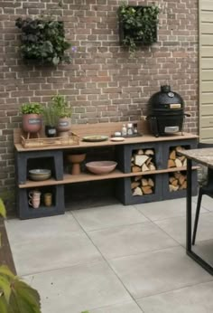 an outdoor table and bench with potted plants on the wall next to brick walls