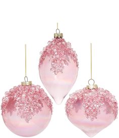 three pink christmas ornaments hanging from strings