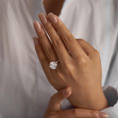 a woman's hand with a diamond ring on her left hand, holding the other hand