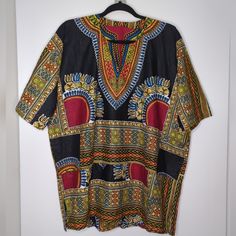 This Is A Wonderful African Dashiki Design With Wonderful Colors Unisex Shirt With Pockets And Shirt Sleeves In Size L, Nwot. It Has No Tags Or Markings, The Fabric Is Cotton And It Has An Amazing Watermark To It That Can Be Seen As You Move In The Light, This Makes It Truly Unique. I Believe It Has Never Been Worn, It Is In Excellent Condition. The Fabric Is Ankara "Guaranteed Wax Block Prints 2 Wins". Measures 26" From Armpit To Armpit And 30" Long With One More Inch In The Back. Dashiki Shirt, African Dashiki, Move In, Unisex Shirt, Shirt Sleeves, Ankara, Block Print, Black And Red, Wax