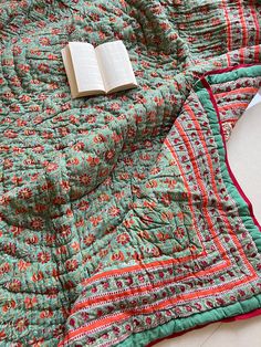 an open book laying on top of a quilt