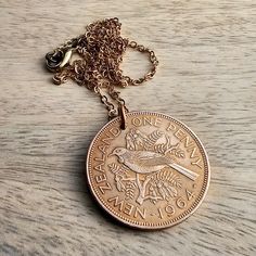 "A 1964 New Zealand one penny vintage coin necklace, featuring a large copper pendant made from a genuine coin, demonetized and out of circulation.  The coin hangs on a durable brass cable chain with lobster claw clasp.  The chain length can be selected at checkout.  The sample length is 24\".  See all photos for specific visual details.   DIAMETER OF COIN: 1 1/4\" (32 mm)  Your 1964 New Zealand bird one penny coin necklace is ideal as a birthday or anniversary gift for someone celebrating a milestone in that year or for someone who loves New Zealand.  It will be gift boxed, ready for giving or storage.   Enjoy! DRWR23" Vintage Round Coin Necklace Gift, Vintage Coin Necklace For Commemoration, Vintage Coin Necklace With Medallion Shape As Gift, Vintage Bronze Coin Necklace, Vintage Medallion Coin Necklace As Gift, Vintage Medallion Coin Necklace For Gift, Vintage Coin Necklaces For Anniversary, Vintage Coin Pendant Necklace As Gift, Vintage Coin Necklace With Charm